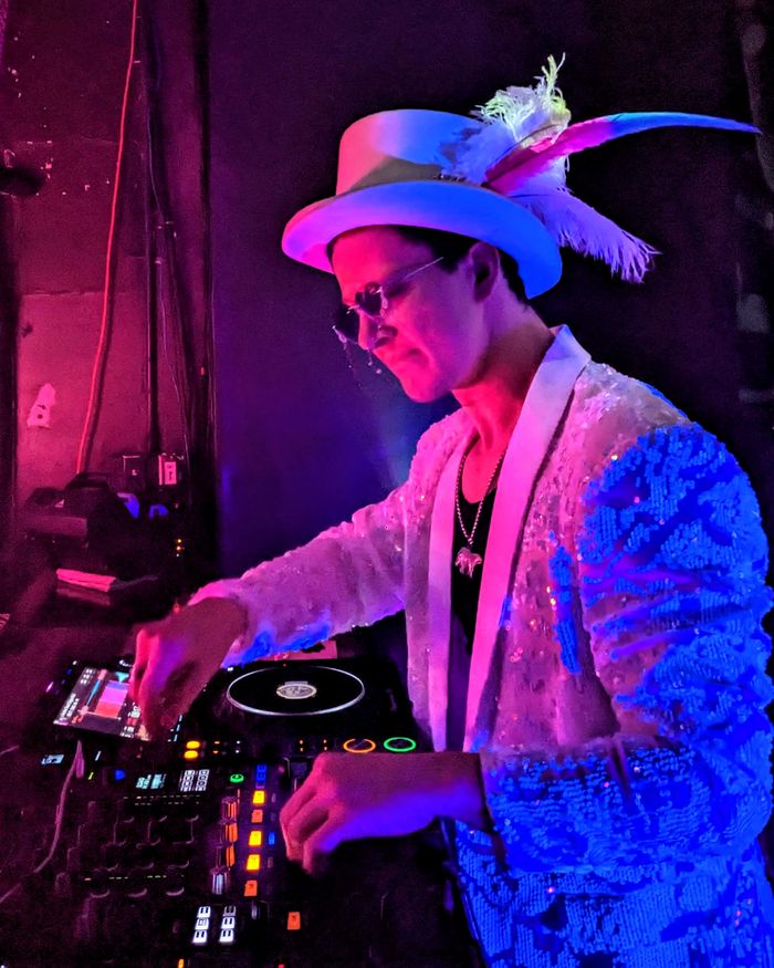 chillbill at the decks in a feathered top hat and blue sequin jacket